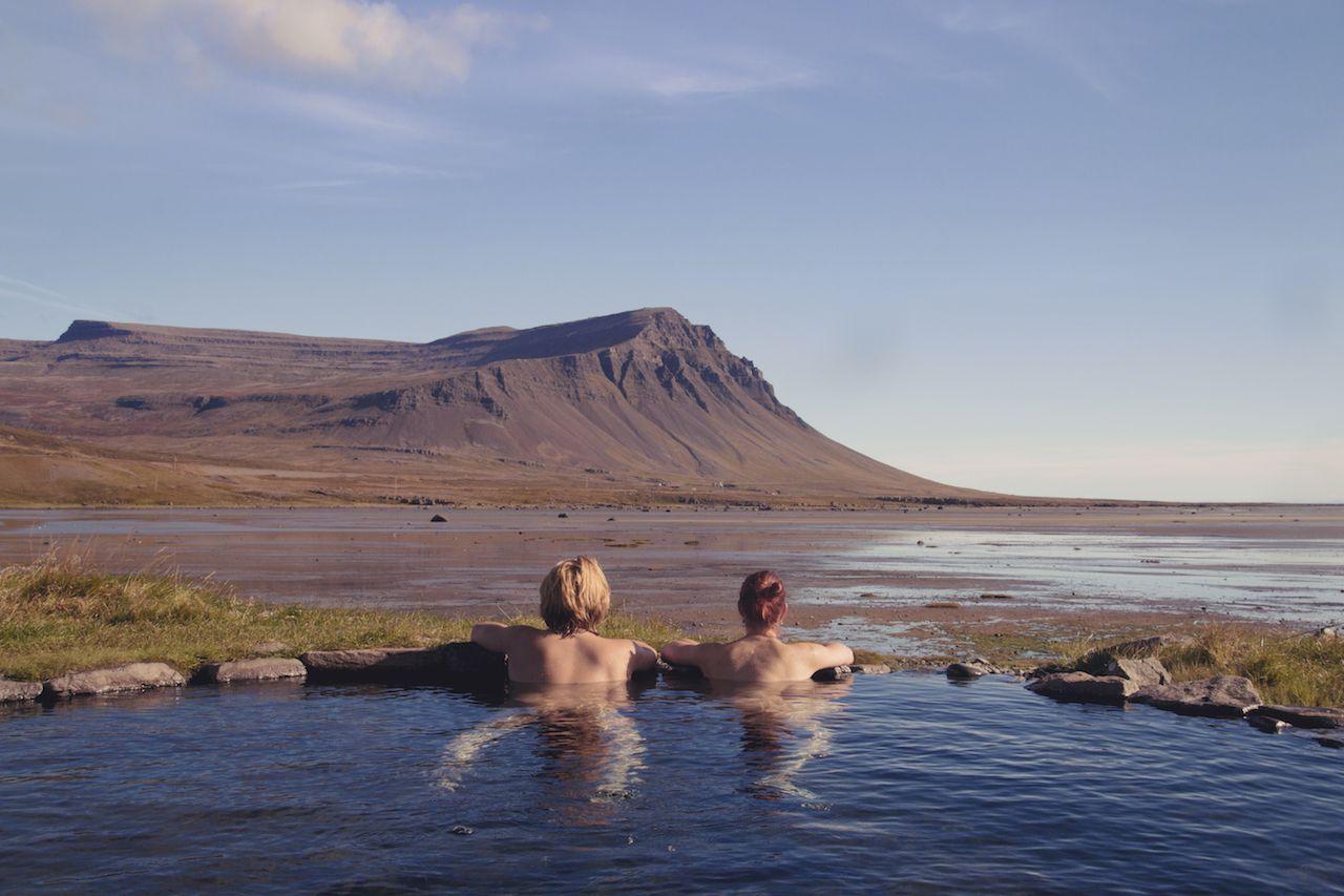 Coppia felice innamorata che si rilassa in una piscina calda con vista spettacolare su un paesaggio selvaggio