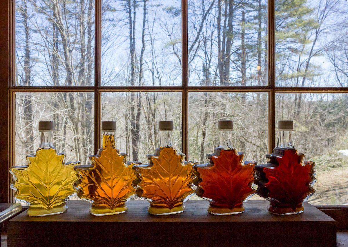 Varie qualità di delizioso sciroppo d'acero del Vermont allineate su un davanzale