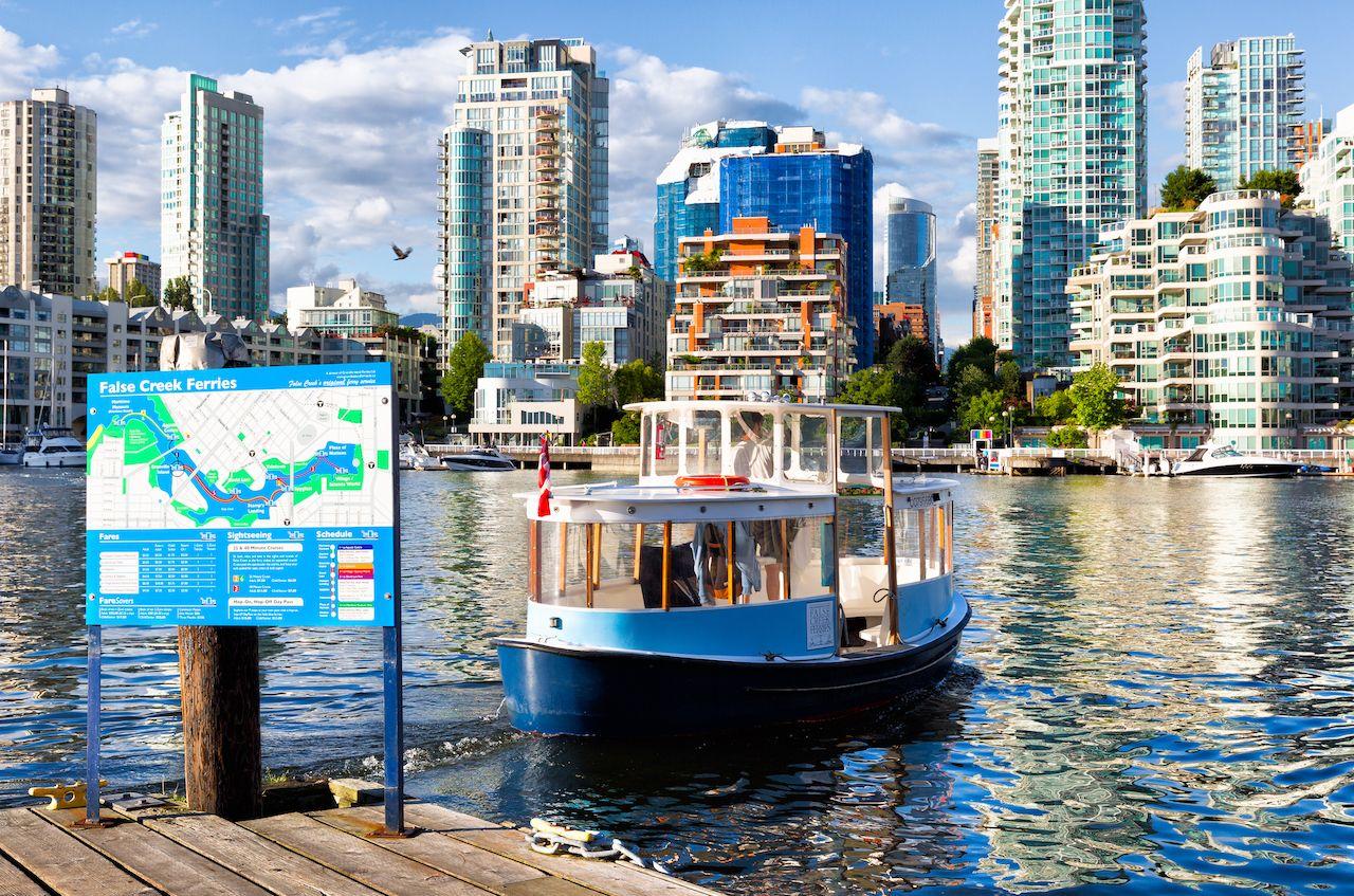 Barca per Granville Island, BC, contro lo skyline della città