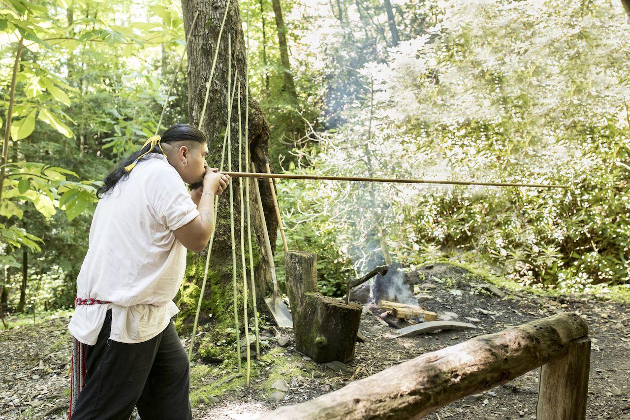 Ein Cherokee Indianer benutzt eine traditionelle Blasrohr