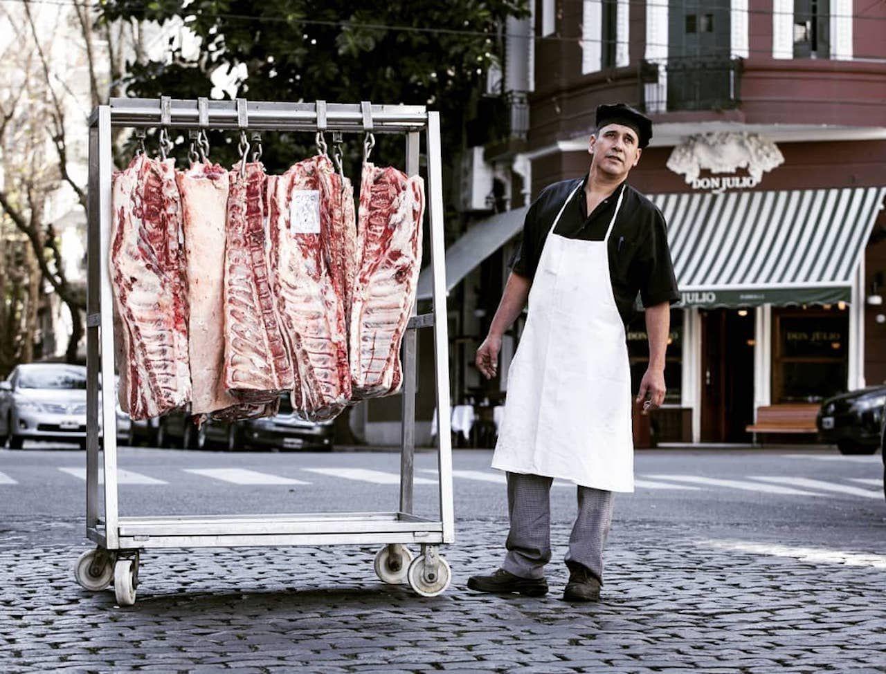 Uomo in piedi vicino a un banco di carne