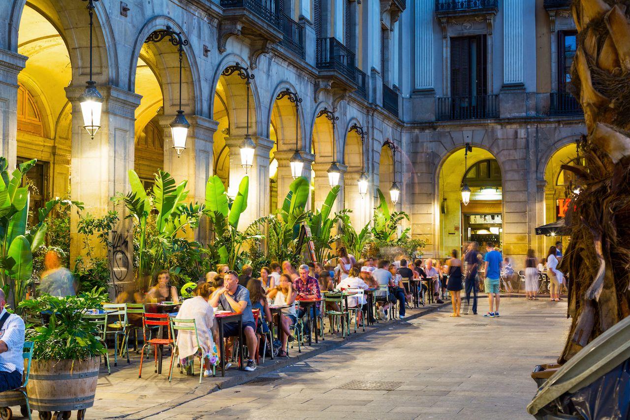 Piazza Reale con ristoranti e altre strutture illuminate di notte a Barcellona